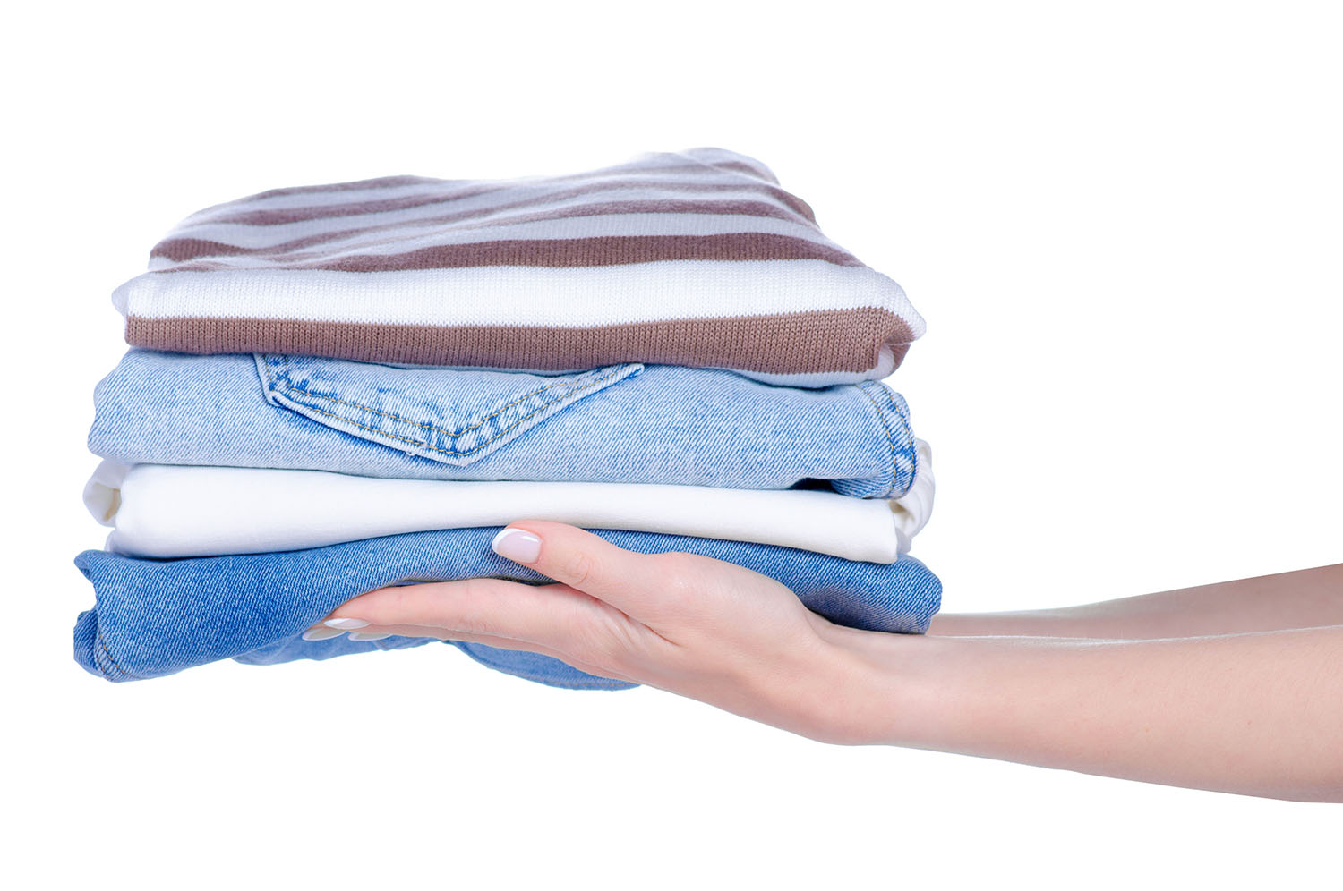 Stack folded cloth jeans sweaters in hand on white background isolation
